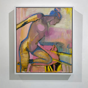 A warm-toned abstract figurative painting hangs in a white frame on a clean, white wall. 