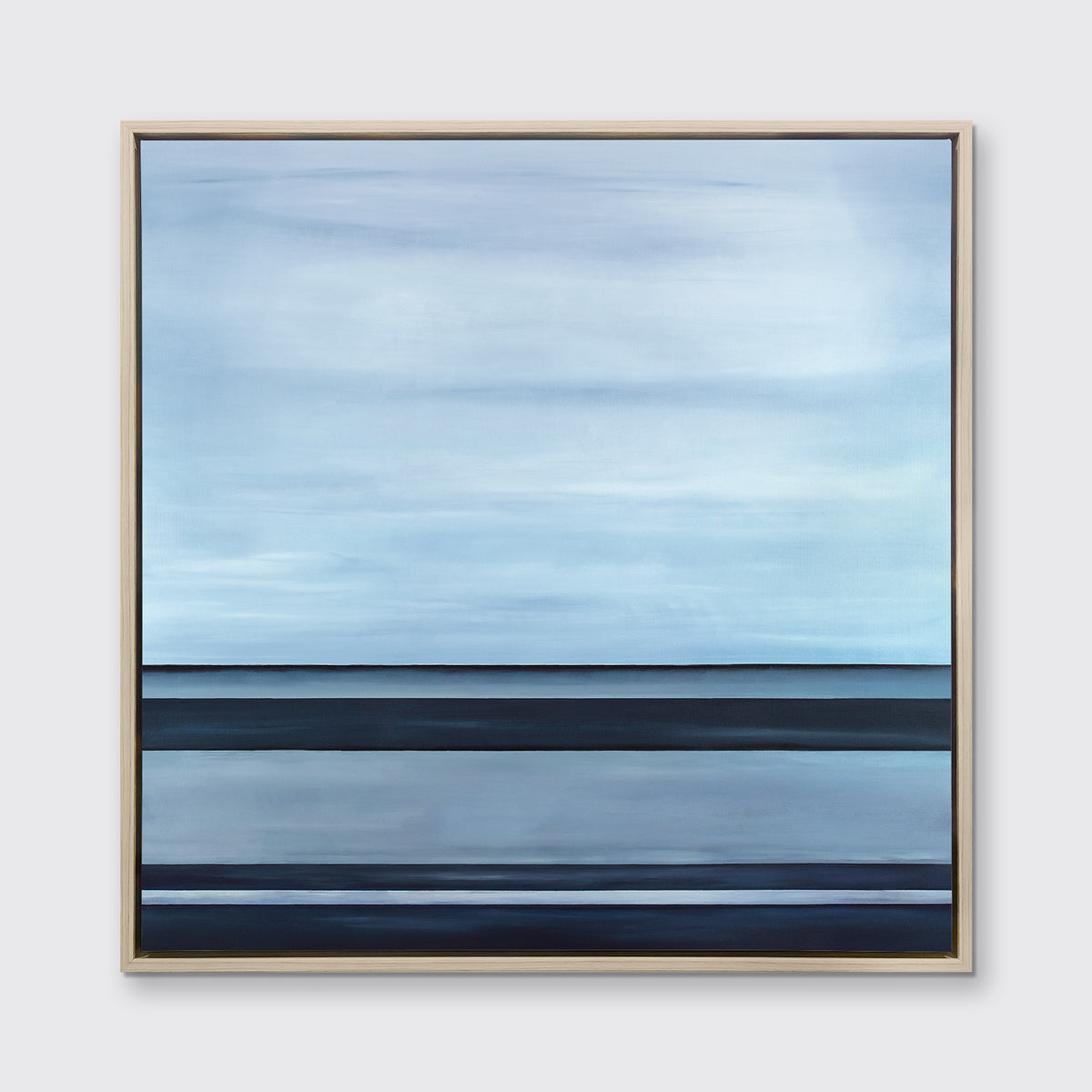 A tonal blue linear abstract print in a white oak wood floater frame hangs on a white wall.
