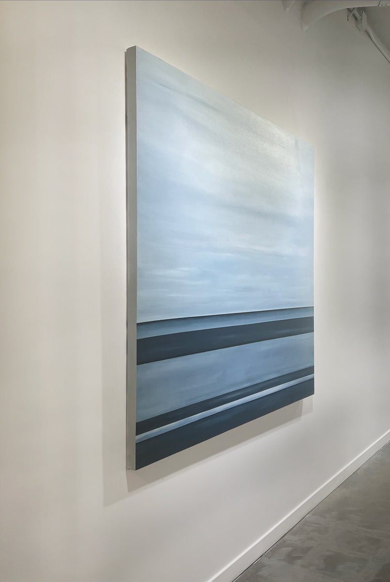 A left side-angle view of a tonal blue linear abstract painting by Tony Iadicicco hangs on a white wall.