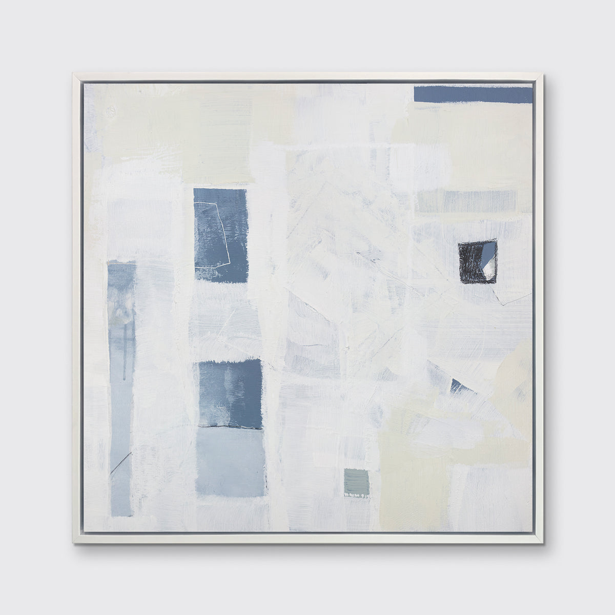 A white, pale yellow and slate blue abstract print in a white floater frame hangs on a white wall.