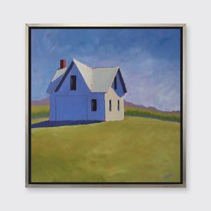 A blue and green contemporary barn print in a silver floater frame hangs on a white wall.