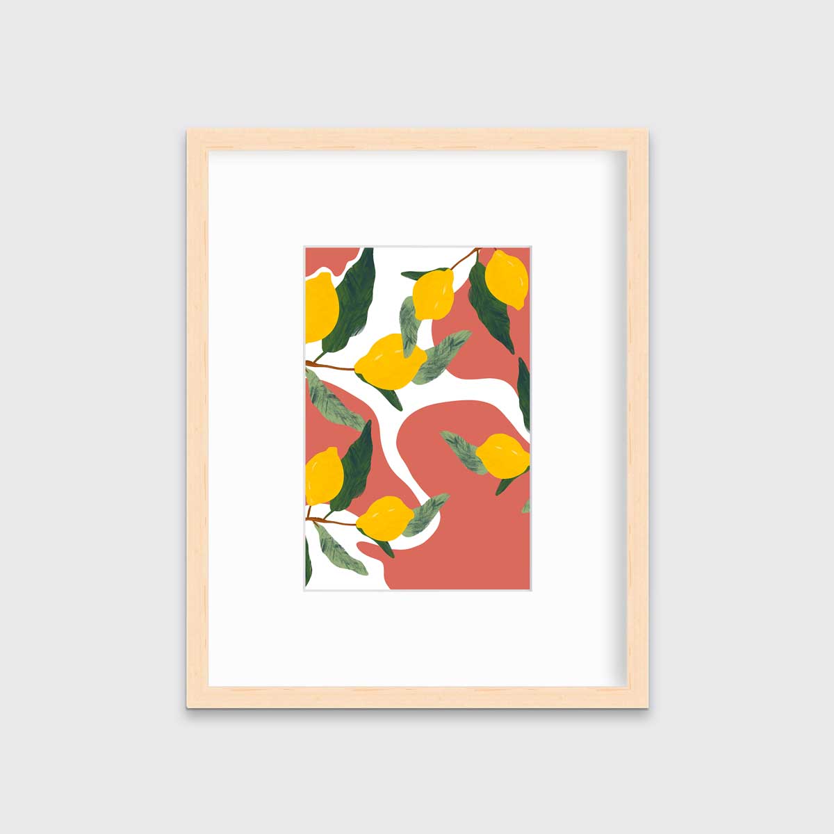 A print of lemons on branches with a terracotta and white organically shaped background in a natural wood frame with a mat hangs on a white wall.