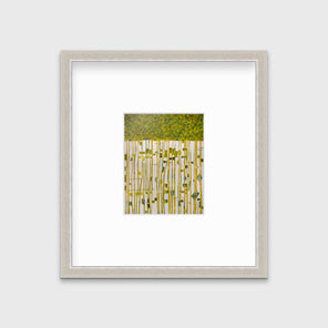 A green, yellow and white abstract print in a silver frame with a mat hangs on a white wall.