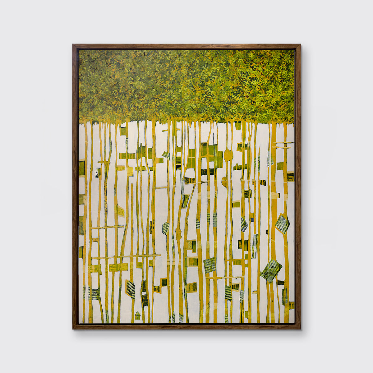A green, yellow and white abstract print in an oak wood floater frame hangs on a white wall.