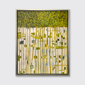 A green, yellow and white abstract print in a silver floater frame hangs on a white wall.