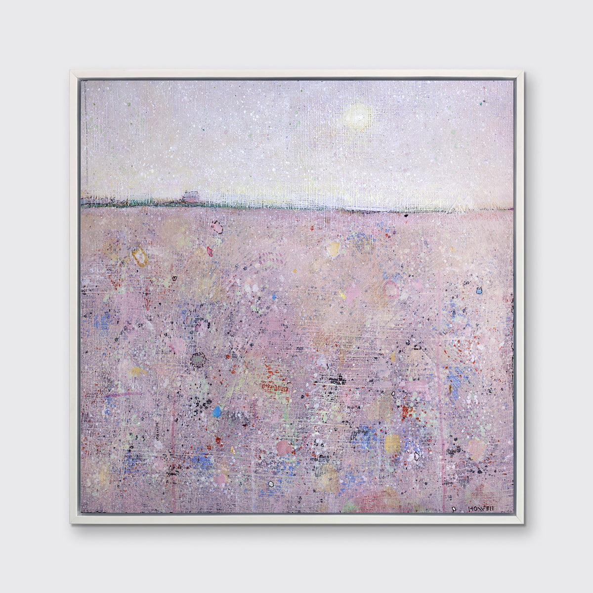 A pink abstract landscape print in a white frame hangs on a white wall.