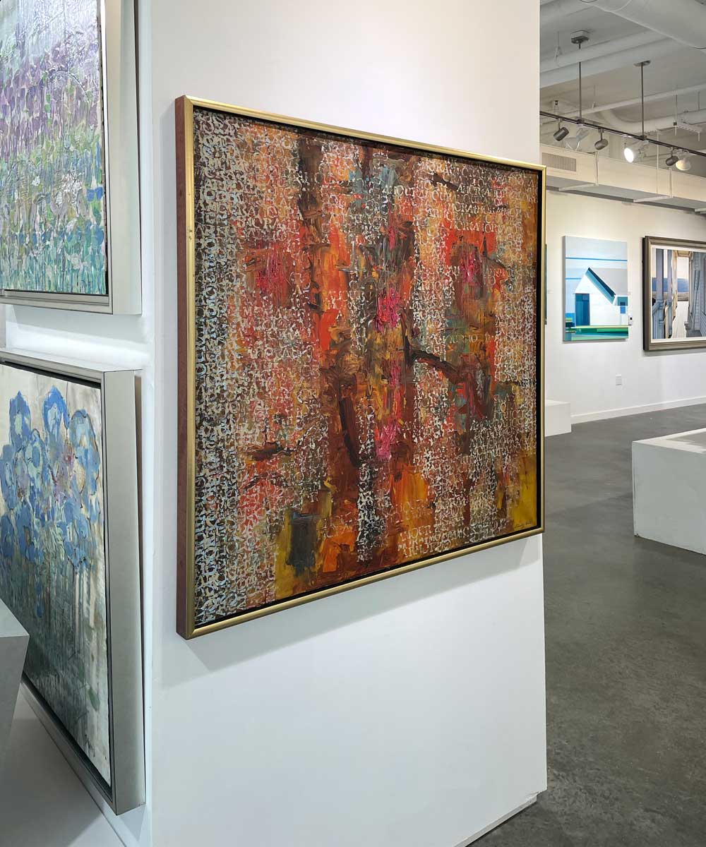 A left side-angle view of a multicolored abstract painting in a warm gold frame hangs on a white wall.