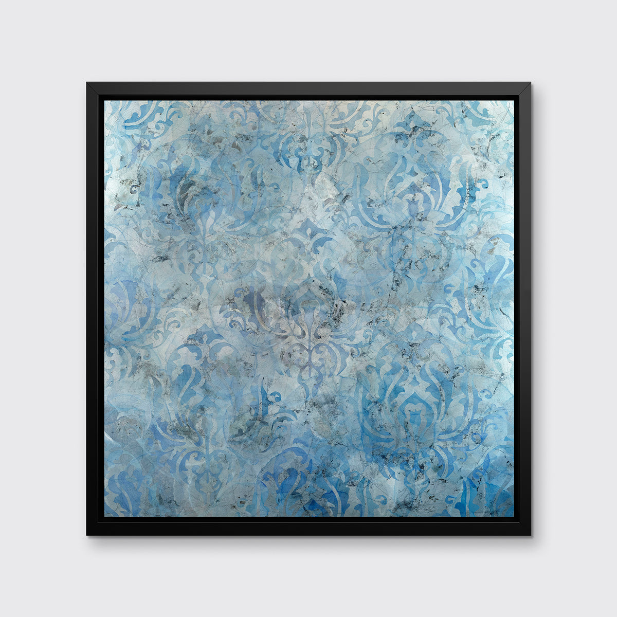 A dark blue, light blue and silver abstract print in a black floater frame hangs on a white wall.