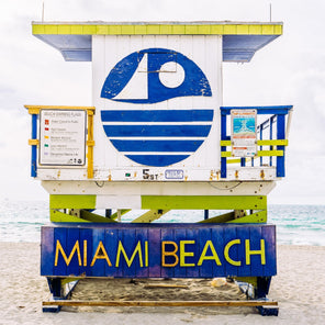 A rear view photograph of a blue and lime green lifeguard stand in Miami, Florida. 