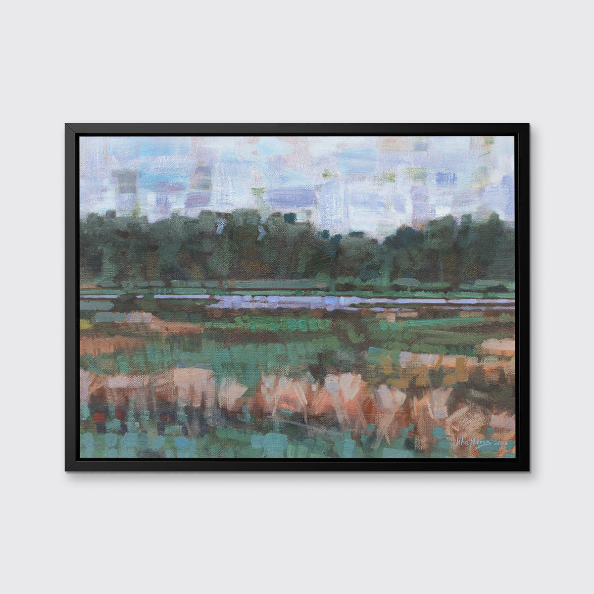 A green, orange and blue abstract landscape print in a black floater frame hangs on a white wall.