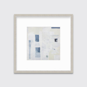 A white, pale yellow and slate blue abstract print in a silver frame with a mat hangs on a white wall.