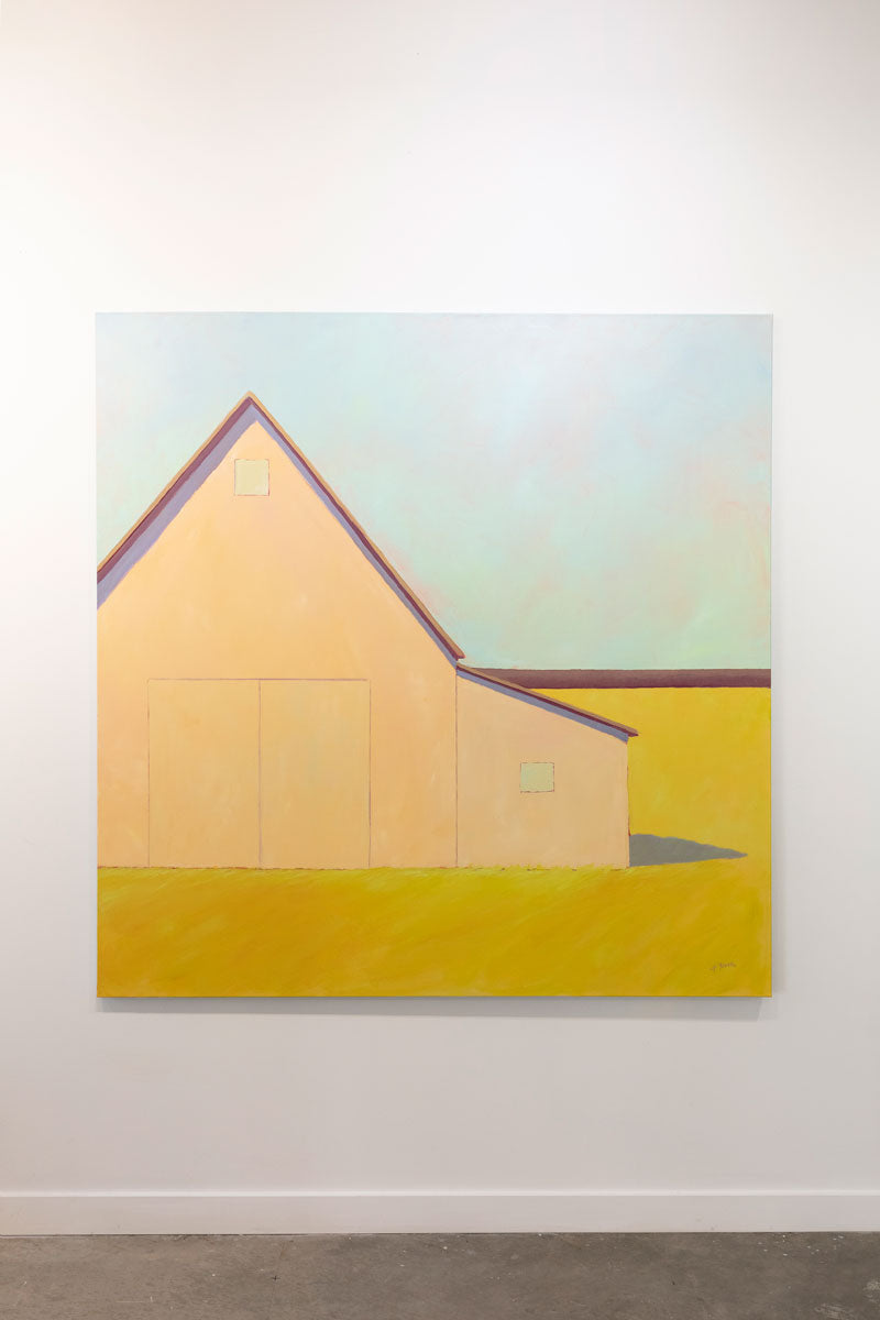 A painting is hung on a gallery wall. In the painting a large, cream-colored barn sits in a yellow field. Wired and ready to hang.