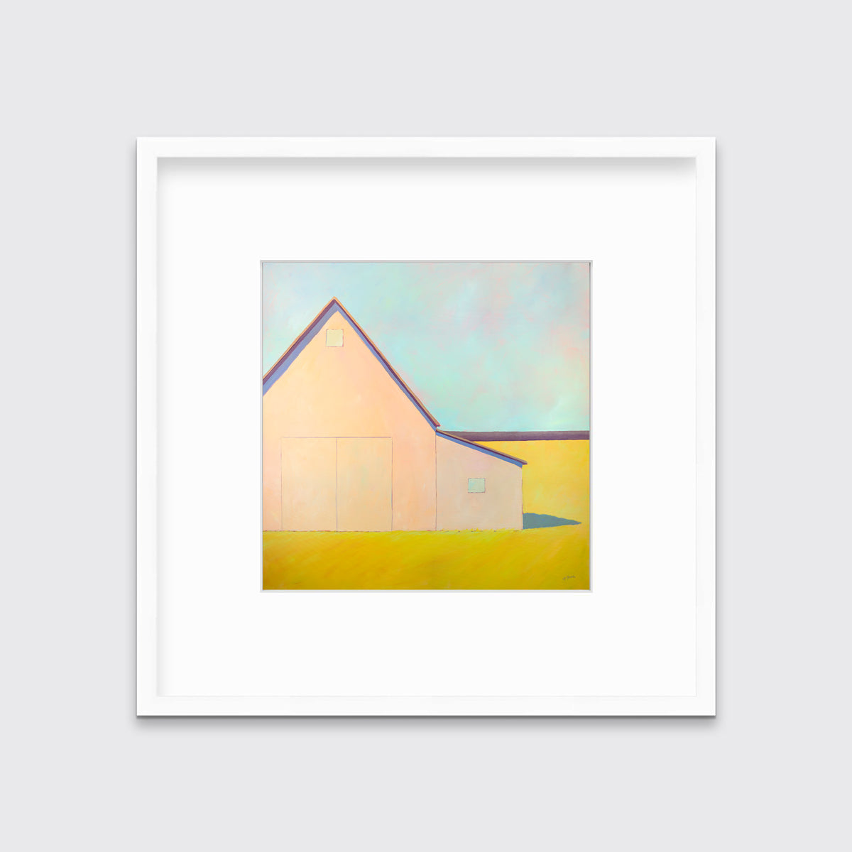 A light blue, coral and deep yellow landscape print of a barn in a white frame with a mat hangs on a white wall.