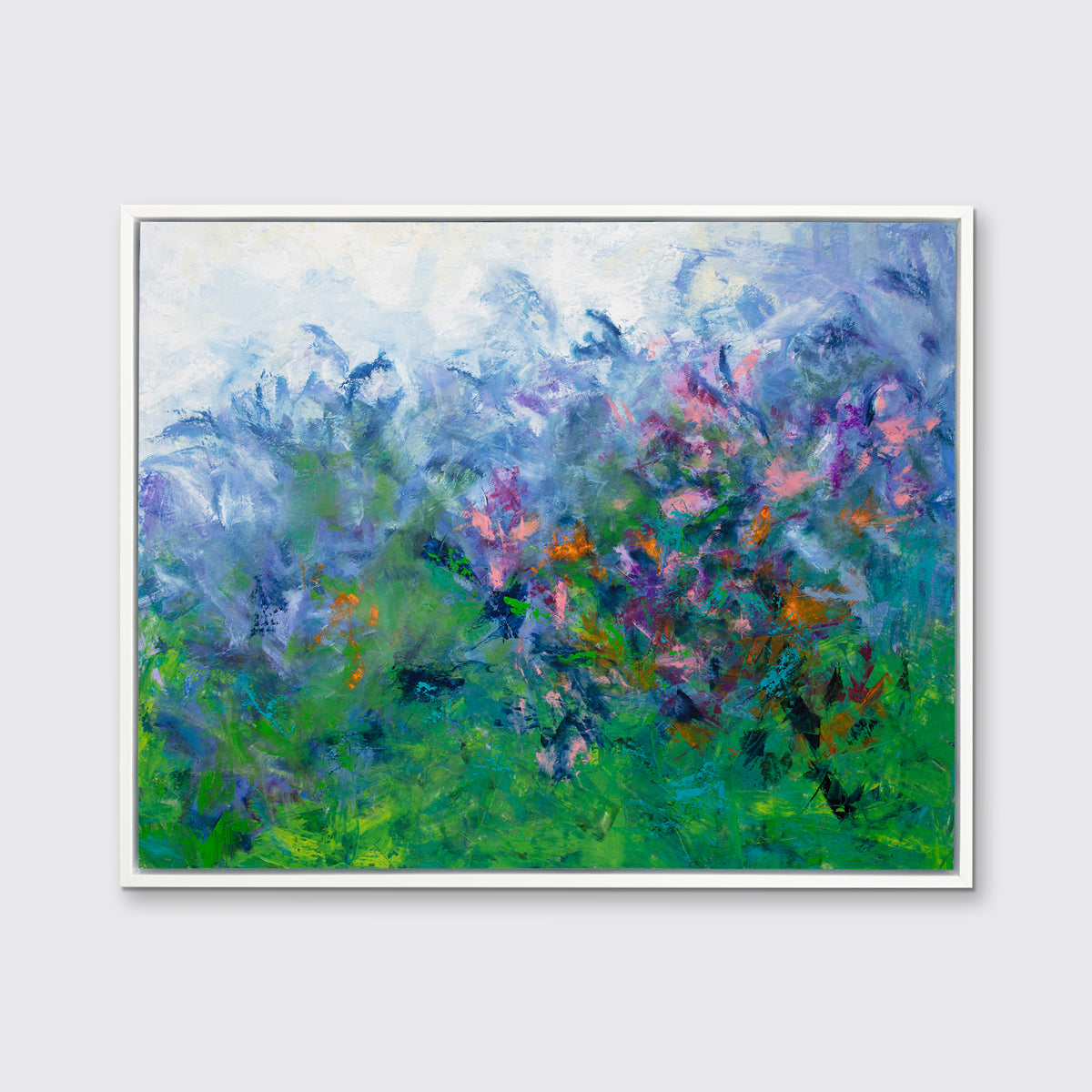 A multicolored abstract floral print in a white floater frame hangs on a white wall.