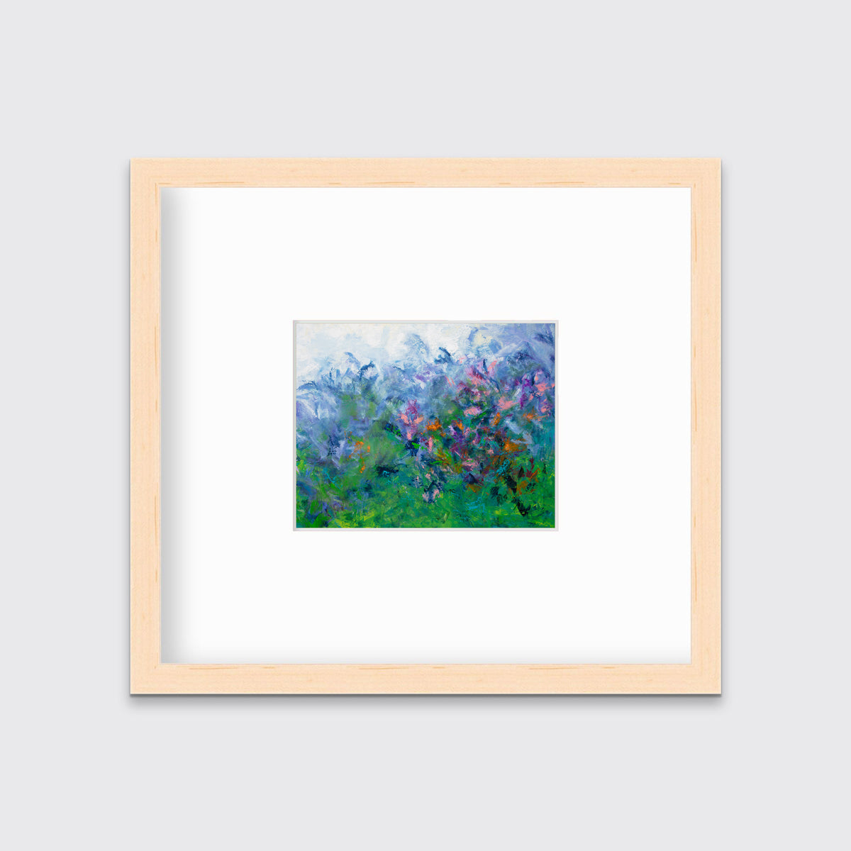 A multicolored abstract floral print in a natural wood frame with a mat hangs on a white wall.