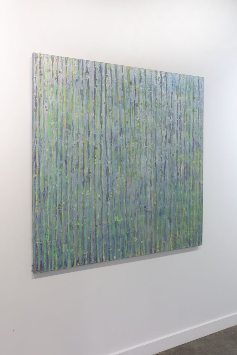 A painting with purple and green undertones and striated with silver lines is seen at an angle. The painting is wired and ready to hang.