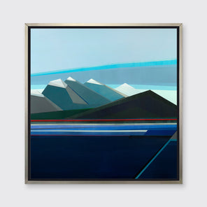 A blue and teal abstract geometric landscape print in a silver floater frame hangs on a white wall.