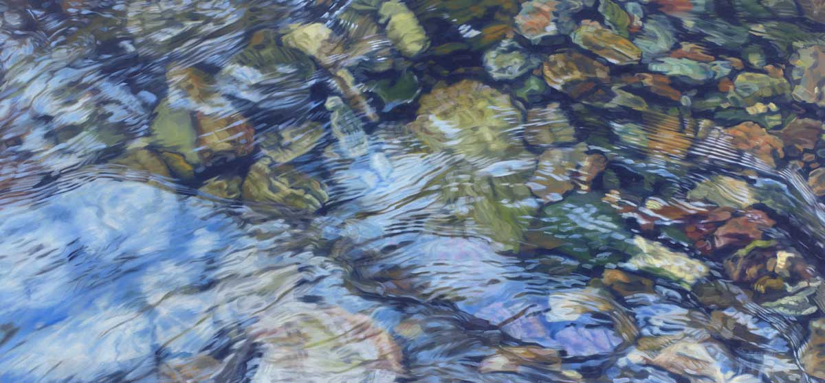 A neutral toned abstract river rock bed with white areas resembling water running over them.