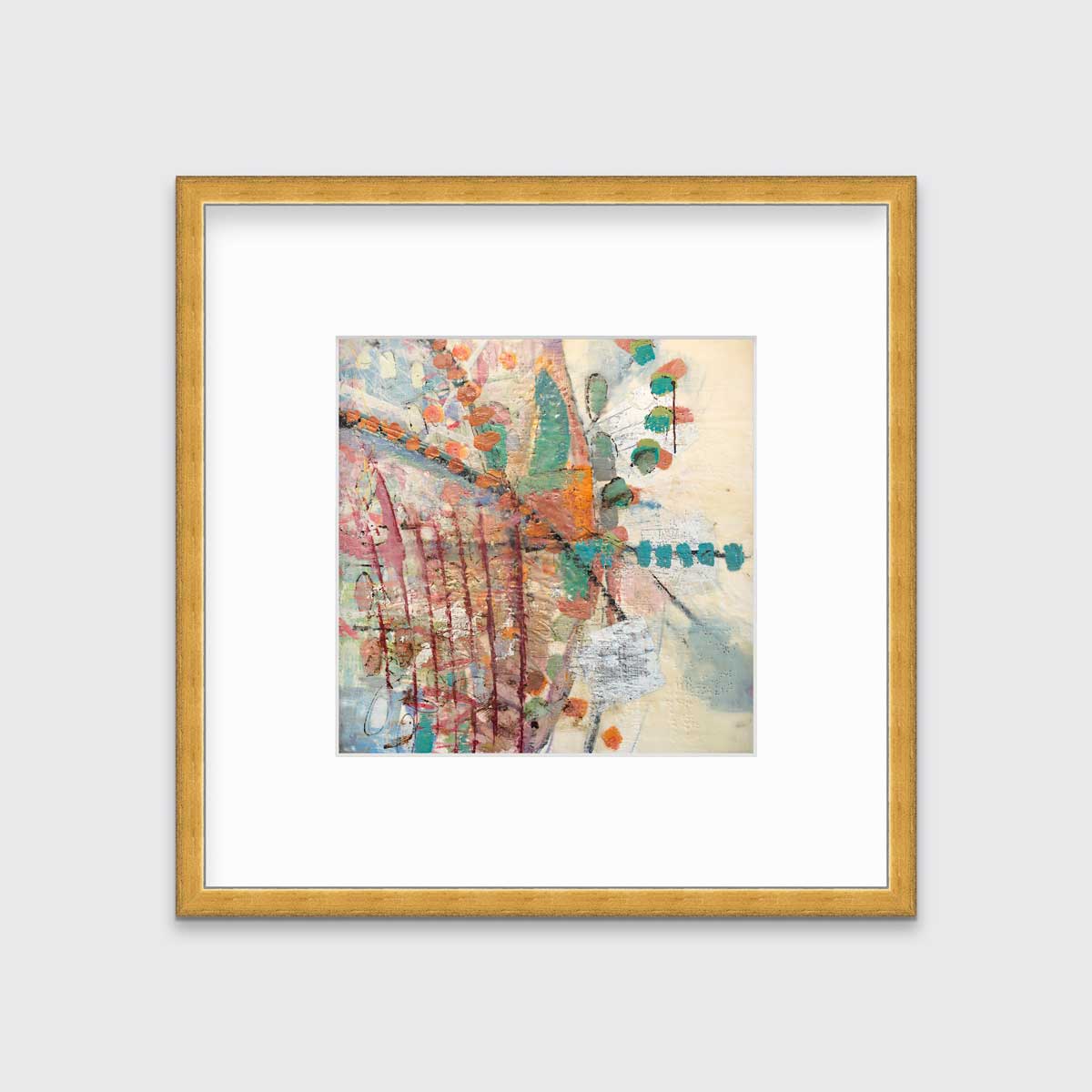 A multicolored abstract print in a gold frame with a mat hangs on a white wall.