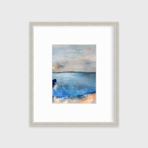 A blue and grey abstract print in a silver frame with a mat hangs on a white wall.