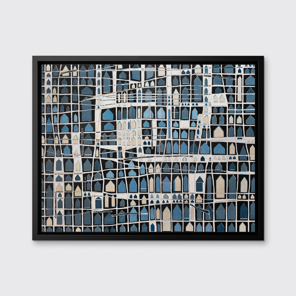 A blue, black, beige and white abstract house print in a black floater frame hangs on a white wall.