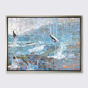A teal and white geometric abstract print of birds flying together in a silver floater frame hangs on a white wall.