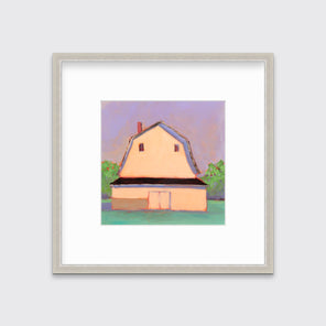 A print of a light orange barn, a lavender sky, green bushes and a teal ground in a silver frame with a mat hangs on a white wall.