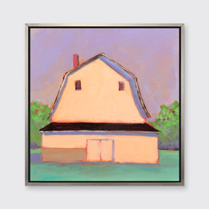 A print of a light orange barn, a lavender sky, green bushes and a teal ground in a silver floater frame hangs on a white wall.