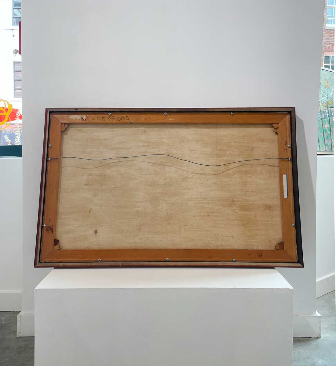 The back of the painting with the title and the hanging wire.