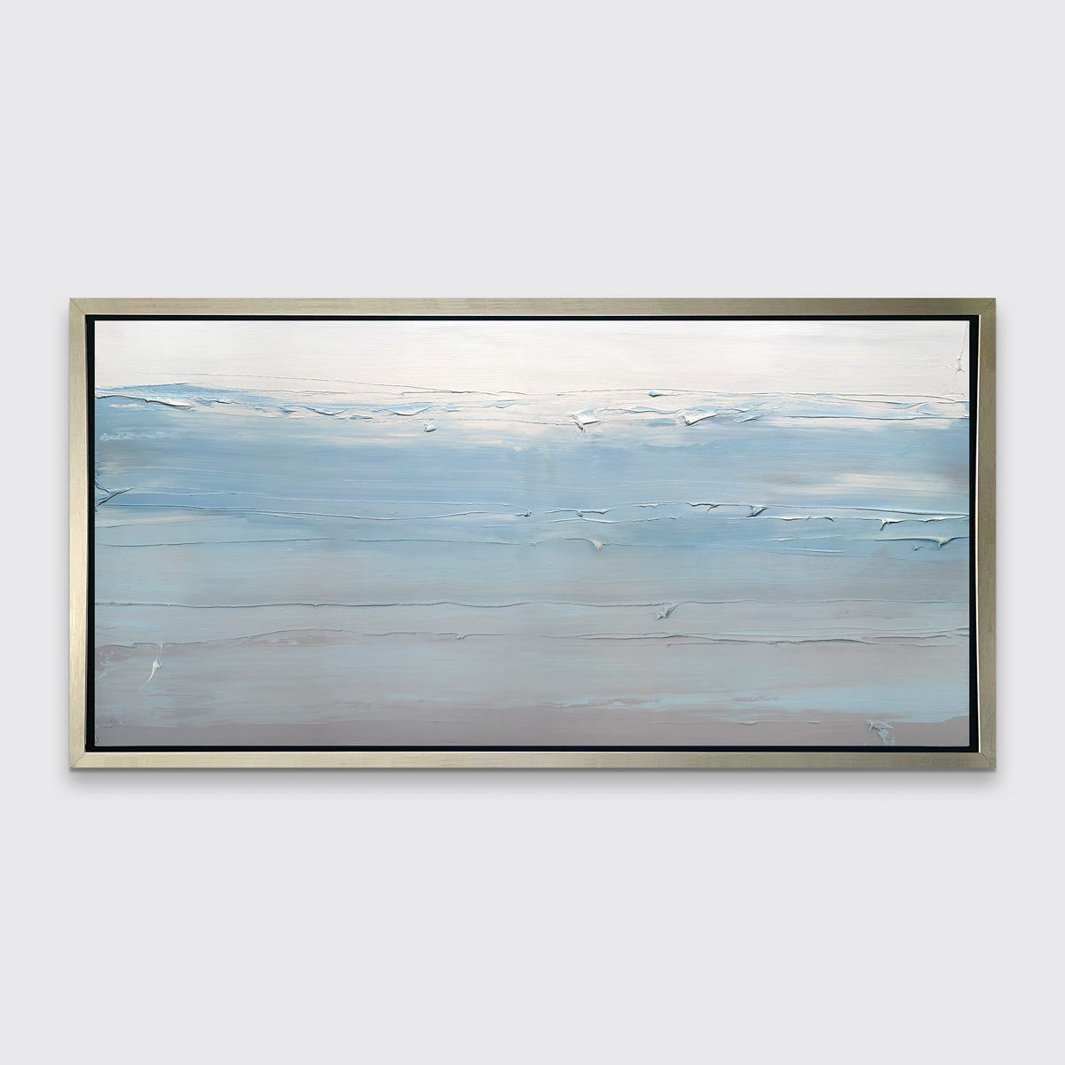 A blue, grey and grey-beige abstract print in a silver floater frame hangs on a white wall.