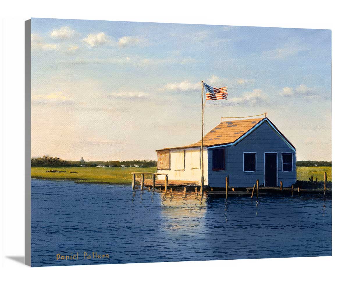 A side-angle view of a blue, beige and green contemporary seascape print with a bay house on canvas.
