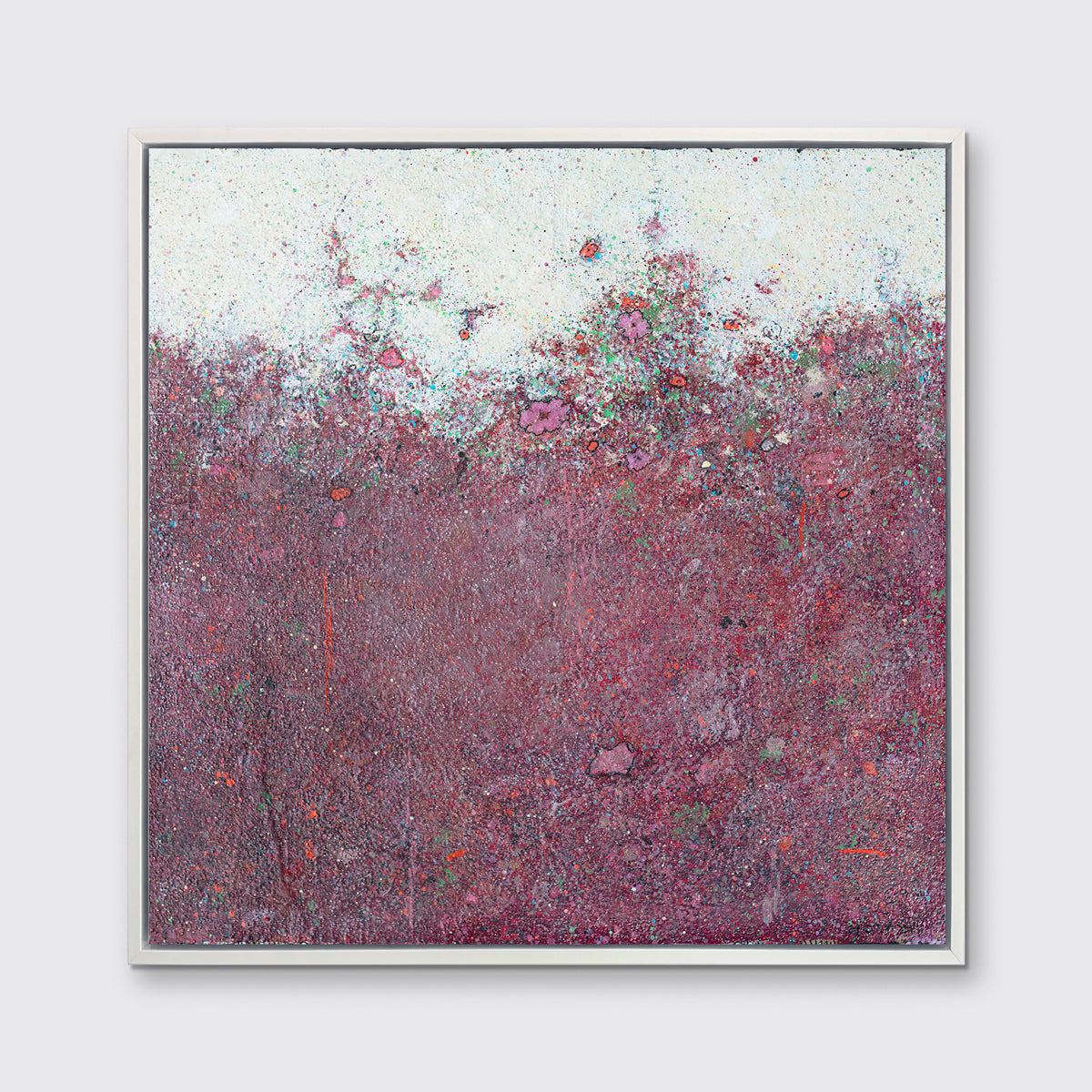 A red abstract landscape print in a white floater frame hangs on a white wall.