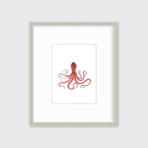 A pink octopus print in a silver frame with a mat hangs on a white wall.