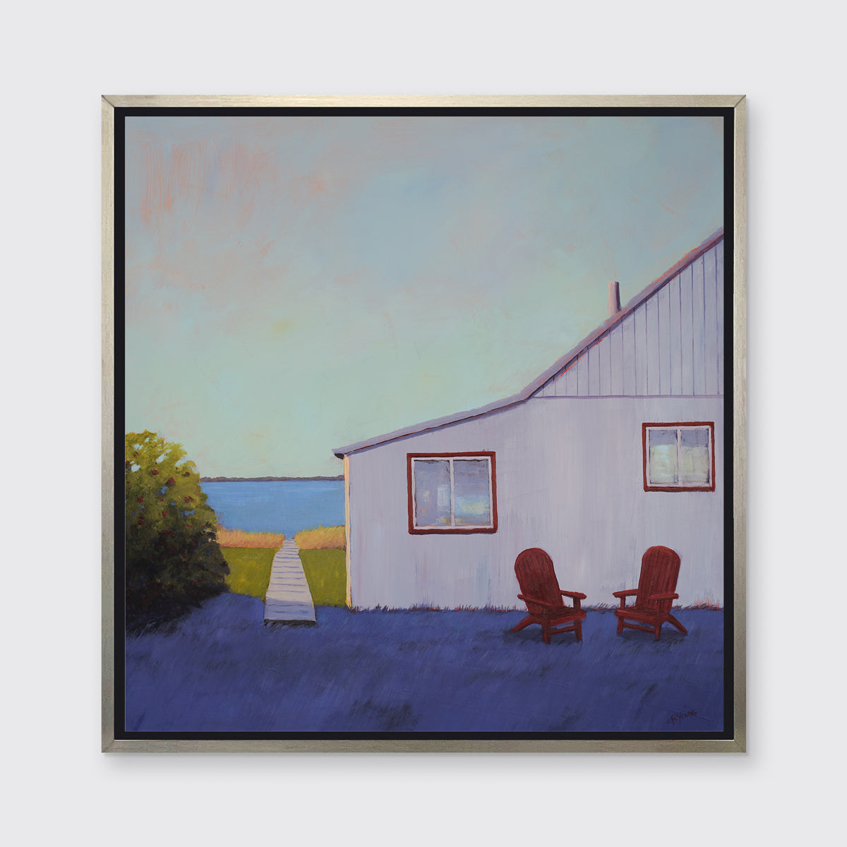 A blue, lavender and light purple contemporary seascape print with a beach house, two red adirondack chairs and a walkway leading to the water in a silver floater frame hangs on a white wall.