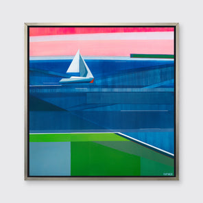 A tonal blue, green and pink geometric abstract landscape print with a sailboat in a silver floater frame hangs on a white wall.