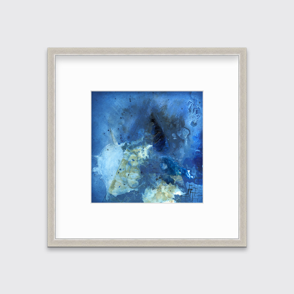 A blue, green and black abstract print in a silver frame with a mat hangs on a white wall.