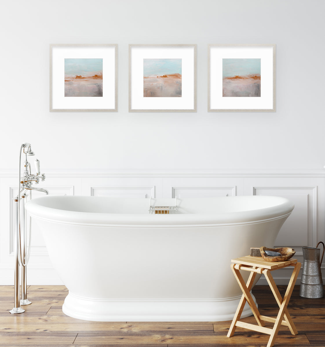 Three teal, copper and dusty pink abstract prints in a silver frames with a mat, hang over a bathtub.
