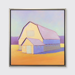A lavender, light yellow and orange landscape print of a barn in a silver floater frame hangs on a white wall.