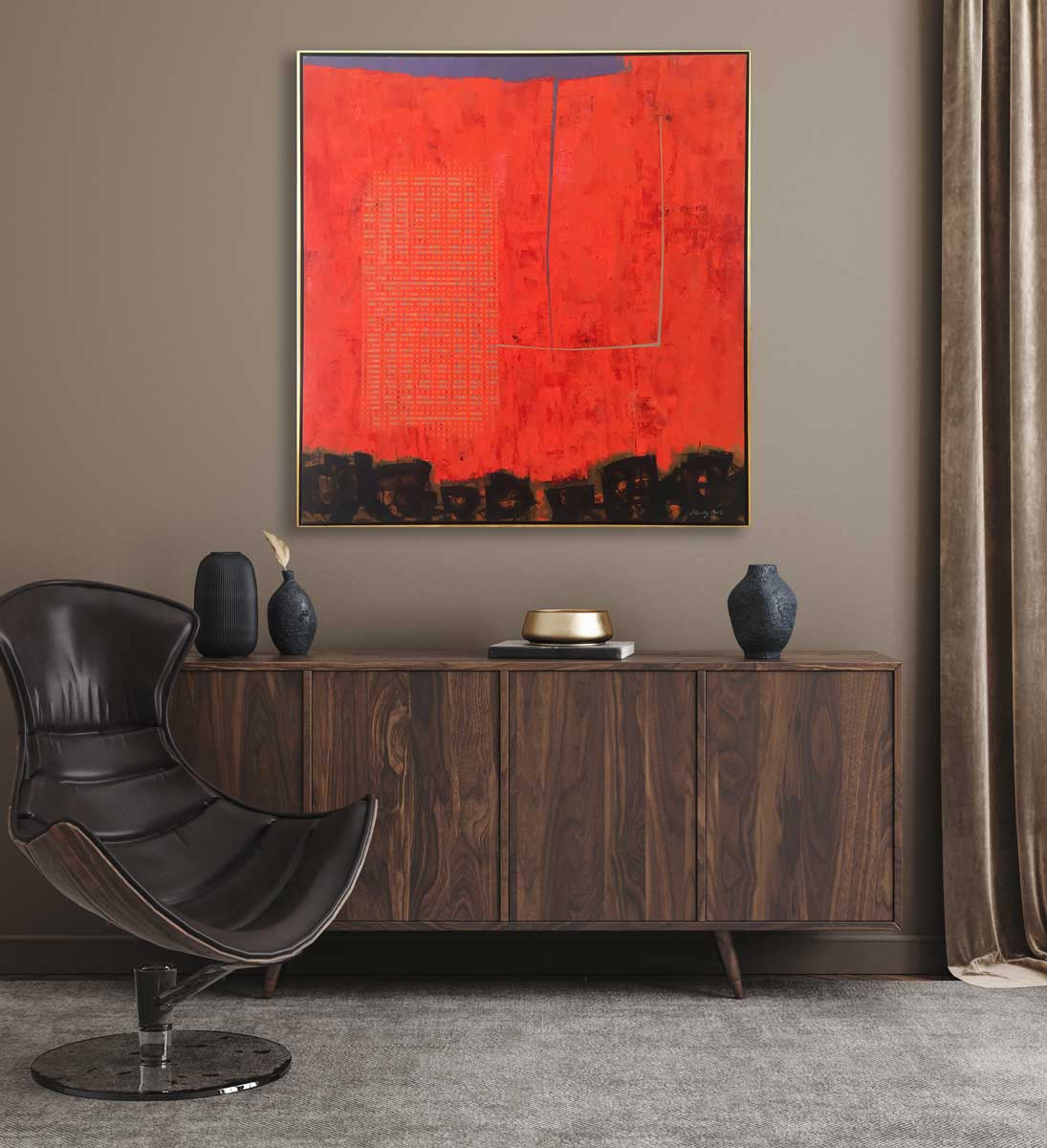 A red abstract painting by Stanley Bate in a gold frame hangs on a tan wall above a dark wood console cabinet with 3 black vases, a gold tray and then a modern chair on a base sits in front.