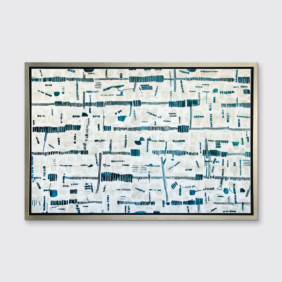 A dark teal, white and beige abstract print in a silver floater frame hangs on a white wall.
