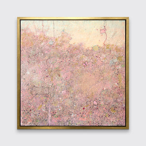 A pink abstract landscape print in a gold floater frame hangs on a white wall.