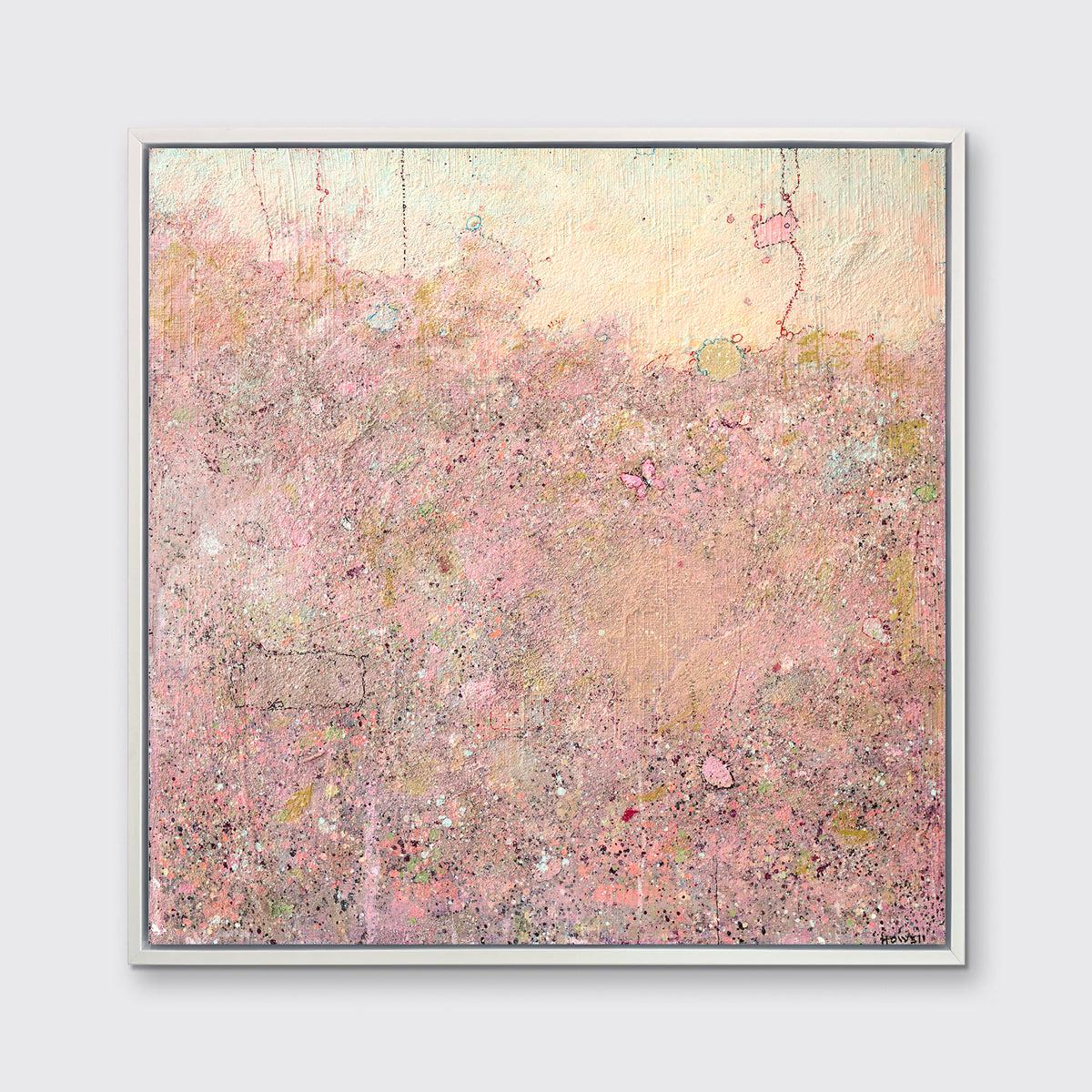 A pink abstract landscape print in a white floater frame hangs on a white wall.