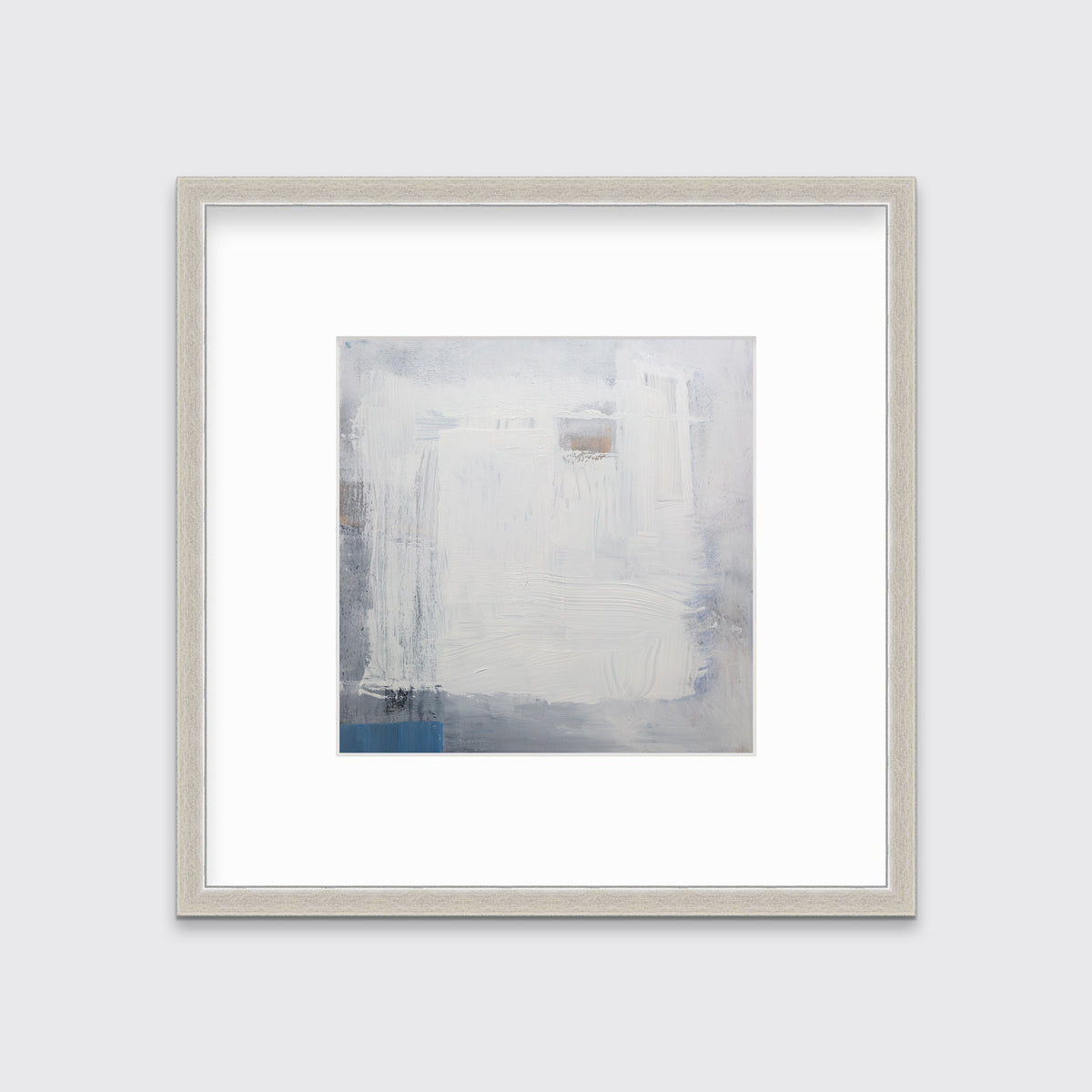 A white, grey and blue abstract print in a silver frame with a mat hangs on a white wall.