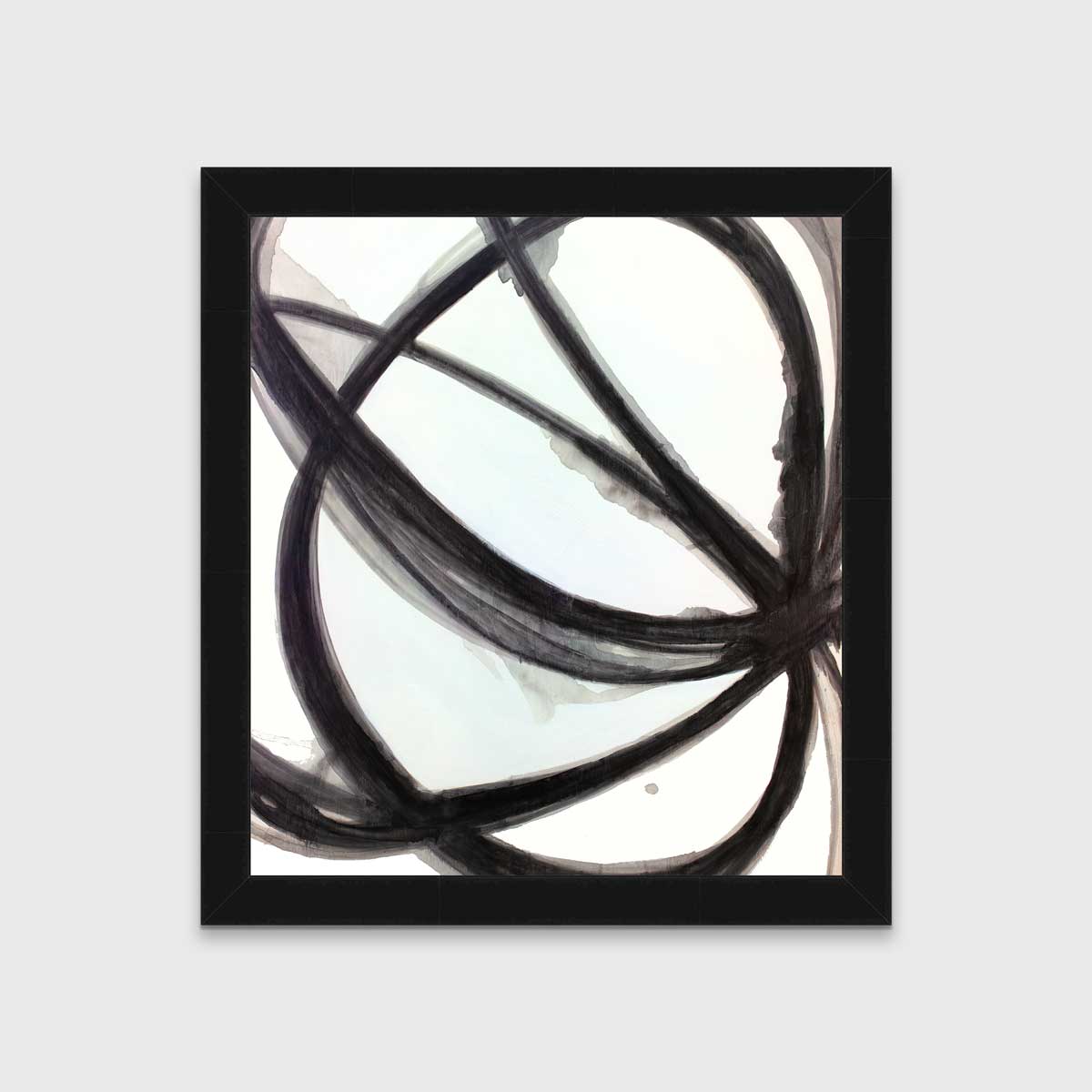 A black, grey and white abstract print in an unmatted black frame hangs on a white wall.