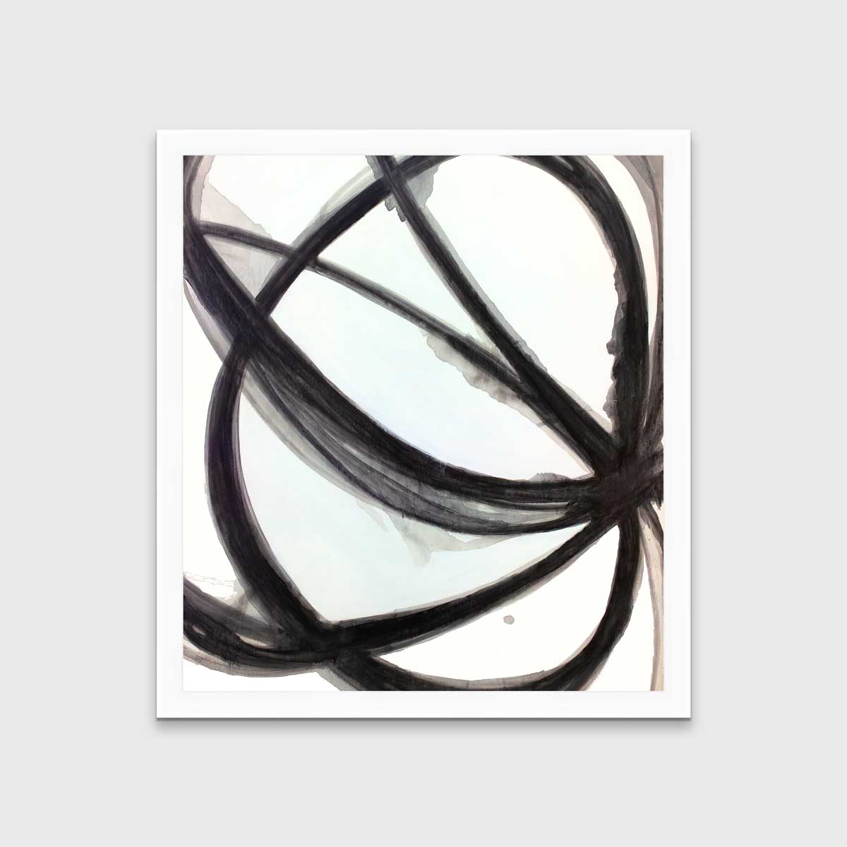 A black, grey and white abstract print in an unmatted white frame hangs on a white wall.