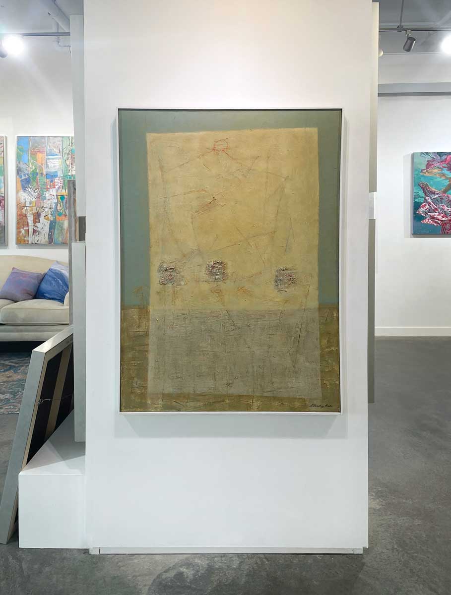 A teal, yellow and grey abstract painting in a white floater frame hangs on a white wall.