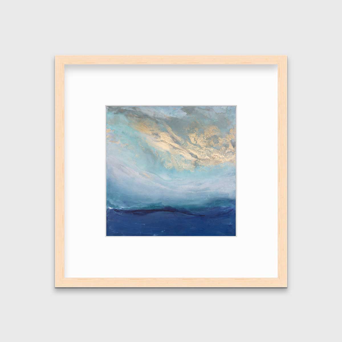 A blue, gold and teal abstract print in a natural wood frame with a mat hangs on a white wall.