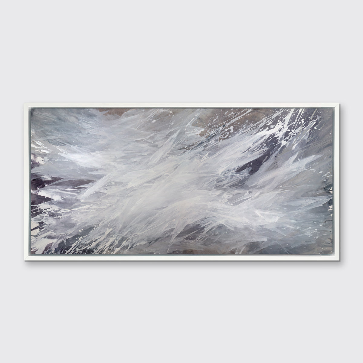 A white, grey and dark grey abstract print in a white floater frame hangs on a white wall.