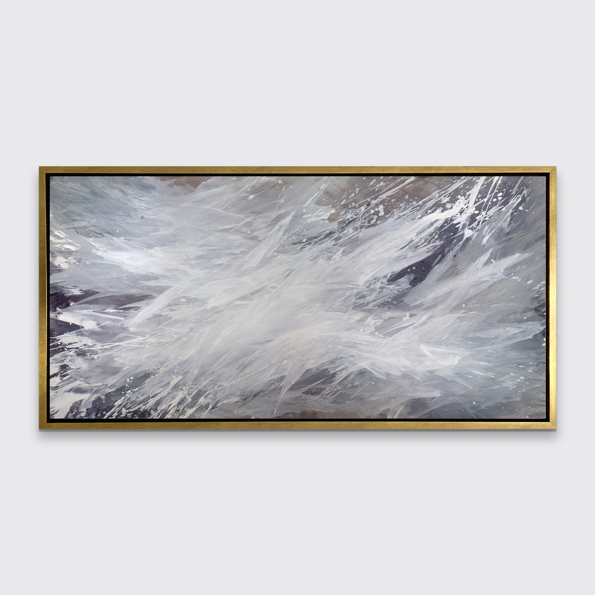 A white, grey and dark grey abstract print in a gold floater frame hangs on a white wall.
