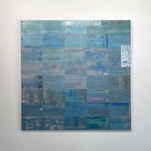 An abstract grid painting with a blue and green wash by Ned Martin hangs on a white wall with a view straight on. 